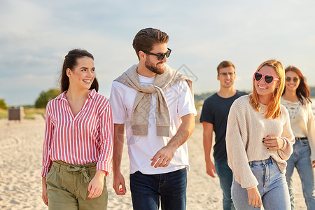 友谊休闲人的群快乐的朋友夏天沿着海滩散步快乐的朋友沿着夏天的海滩散步背景图片