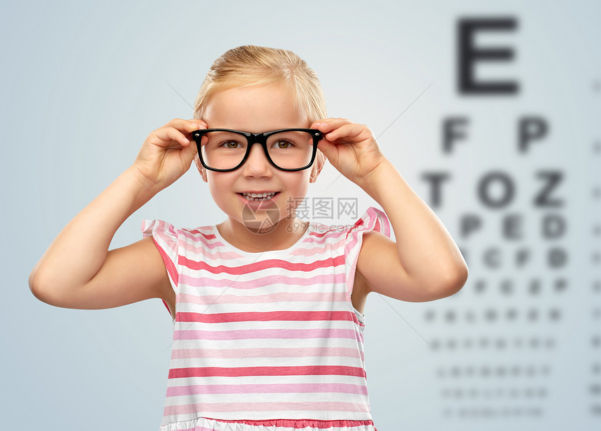 视力视力微笑可爱的小女孩戴着黑色眼镜眼睛测试图表背景快乐的小女孩戴着眼镜了眼睛测试图图片