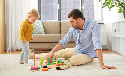 家庭,父亲人的快乐的父亲小宝贝女儿家里玩木制玩具积木套件父亲家里小女儿玩背景图片