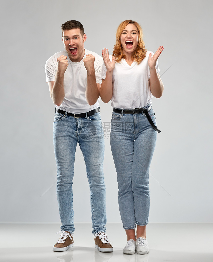 情感人的幸福的夫妇白色T恤庆祝成功的灰色背景穿着白色T恤的幸福夫妇的肖像图片