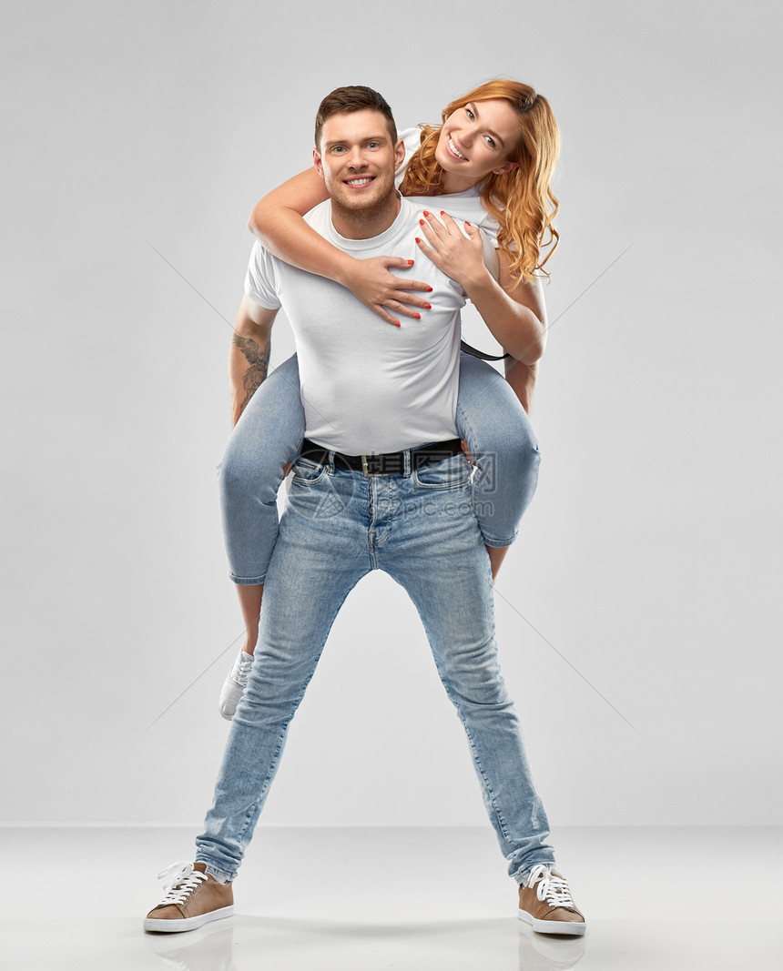 关系人的幸福的夫妇白色T恤上的肖像,灰色背景下玩得很开心穿着白色T恤的快乐夫妇玩得很开心图片