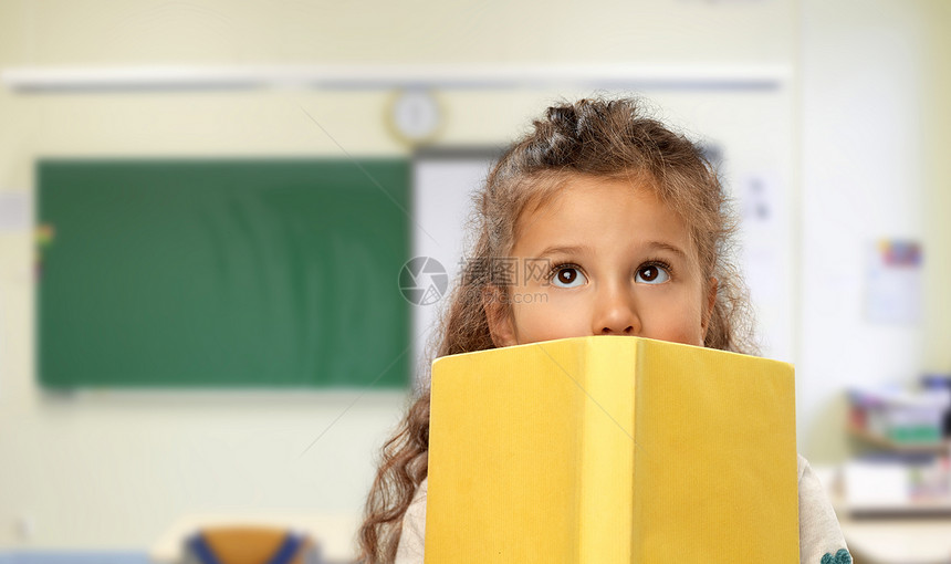 学校,教育学小女孩躲黄色的书后面的课堂背景学校里躲黄色书后面的小女孩图片