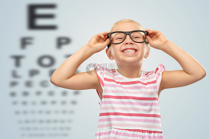 视觉儿童微笑可爱的小女孩戴着黑色眼镜眼睛测试图表背景微笑的小女孩戴着眼镜眼睛测试图表上图片
