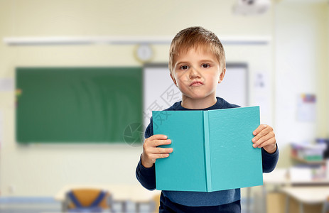 学校,教育学高兴的小男孩阅读书籍的课堂背景学校里,小男孩喜欢书图片