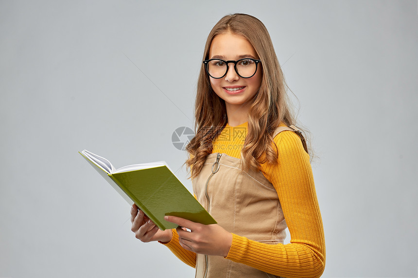 高中,教育视觉微笑的十几岁的学生女孩眼镜阅读书的灰色背景十几岁的学生女孩戴着眼镜看书图片