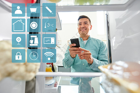 手机列表素材健康的饮食,技术饮食快乐的中年男子与智能手机列出必要的食物冰箱厨房蓝色白色智能家居应用图标有智能手机的男人冰背景