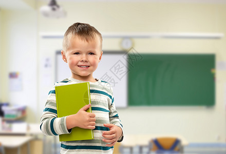 学校,教育学微笑的小男孩课堂背景下着书的肖像微笑男孩学校书的肖像图片