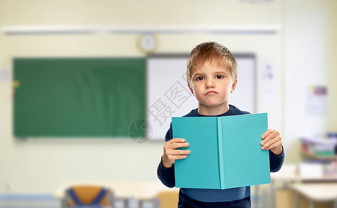 学校,教育学高兴的小男孩阅读书籍的课堂背景学校里,小男孩喜欢书图片