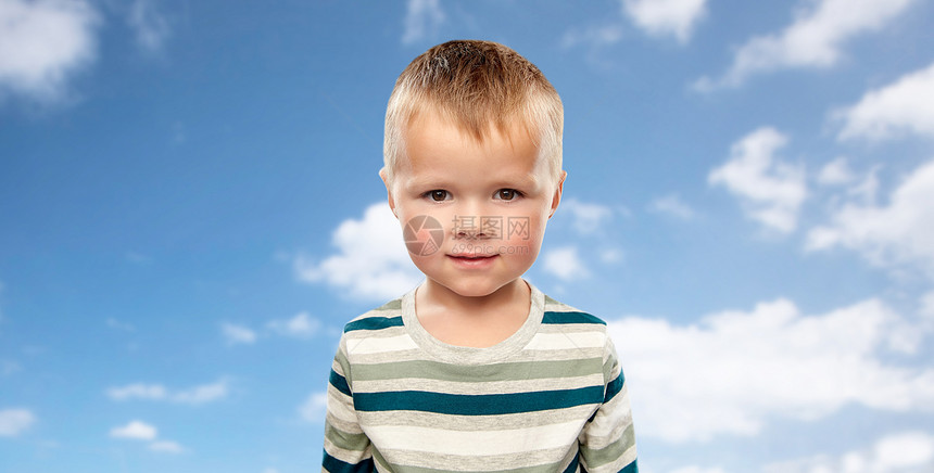 童年人的小男孩穿条纹衬衫蓝天云背景上的肖像蓝天上穿条纹衬衫的小男孩图片
