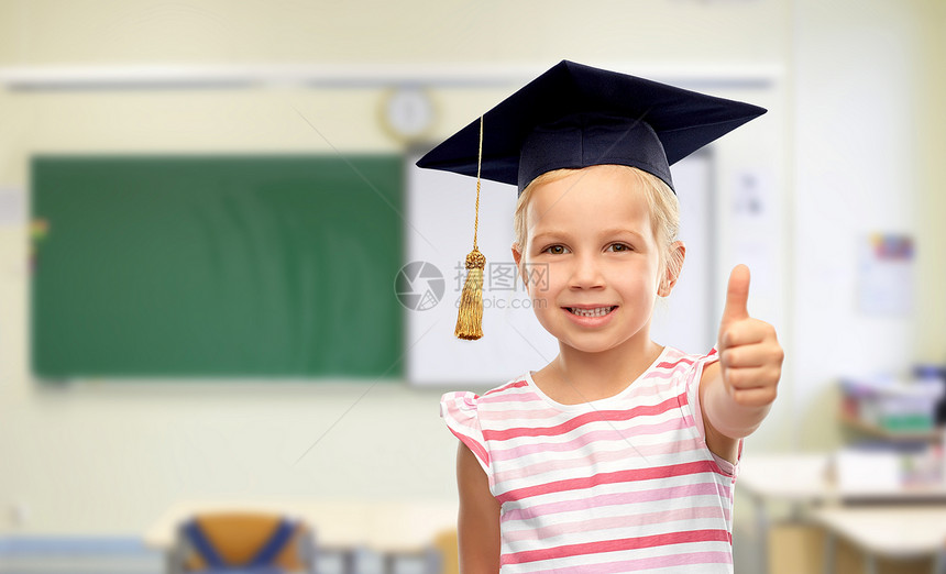 学校,教育学的快乐的小女孩戴着学士帽或黑板,课堂背景上竖起大拇指黑板上的女孩学校竖起大拇指图片