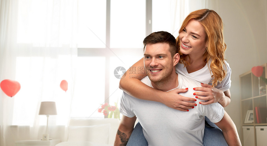 爱情,情人节人际关系的幸福的夫妇白色T恤上的肖像,装饰着心形气球背景的家庭房间里玩得很开心幸福的相爱的夫妇图片