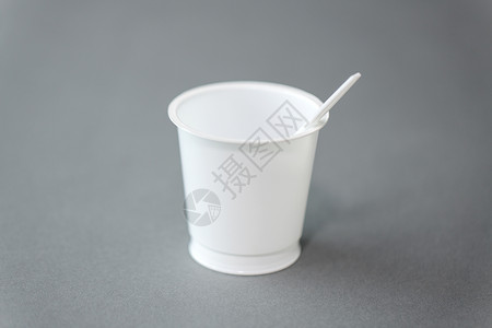 饮食,回收生态白色次塑料杯与勺子灰色背景带勺子的白色次塑料杯图片