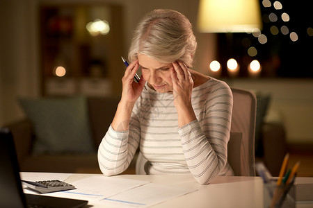 老年压力压力高的老年妇女晚上家填写纳税表老年妇女晚上家填写纳税表图片
