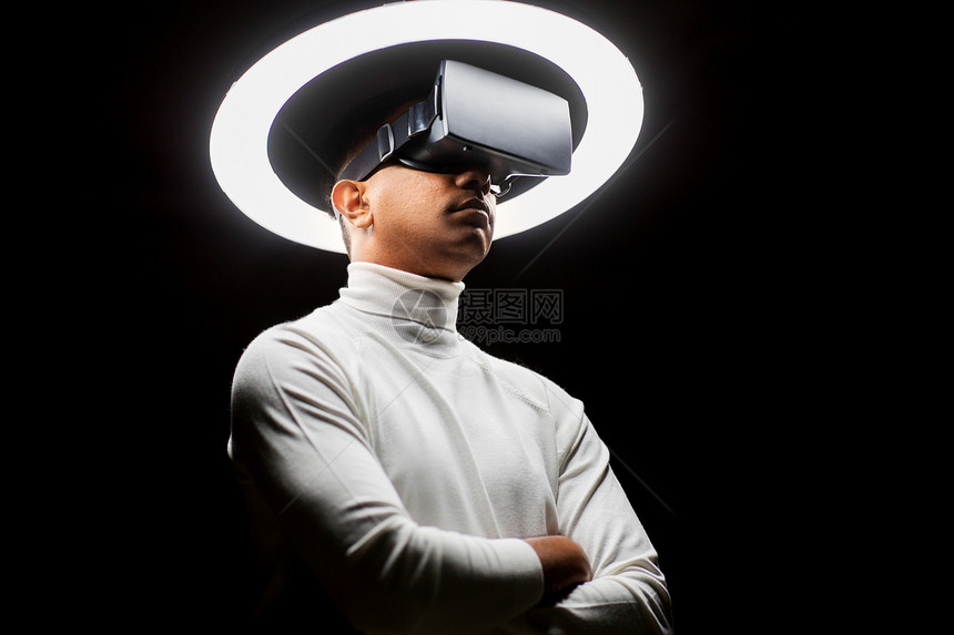 未来的技术,增强现实人的人虚拟现实耳机或VR眼镜白色照明下黑色背景虚拟现实耳机或VR眼镜中的男人图片