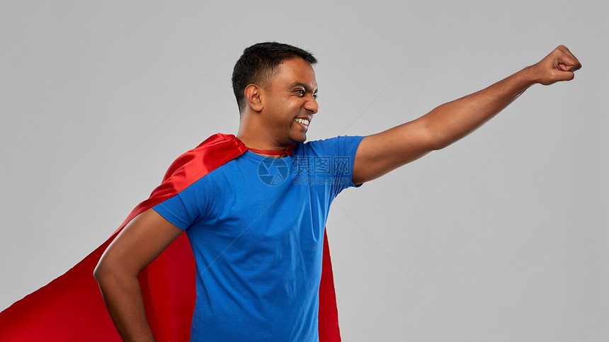 超级力量人的印度男人穿着红色超级英雄斗篷,灰色背景上做获胜的手势穿着超级英雄斗篷的印度男人做了获胜的手势图片