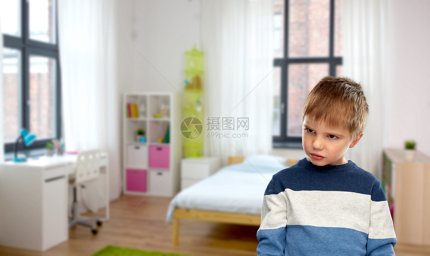 童年,表情人的阴郁的小男孩穿条纹套头衫家里的房间背景家里阴郁的小男孩的肖像图片