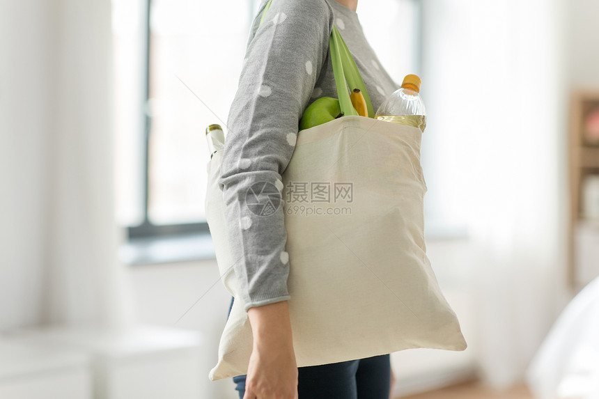 消费主义,饮食生态友好的妇女与白色可重复用的帆布袋,用于食品购物的灰色背景妇女与可重复用的帆布袋食品购物图片