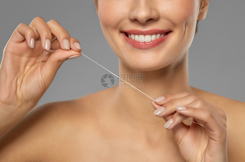 口腔卫生,牙科护理健康密切微笑的年轻妇女用牙线清洁牙齿微笑的女人用牙线清洁牙齿图片