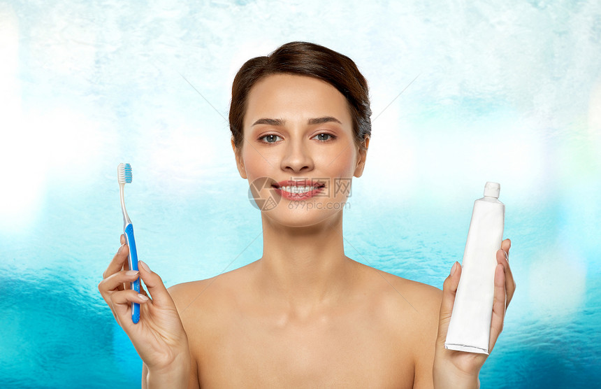 口腔卫生,牙科护理健康理念微笑的女人用牙刷牙膏蓝色的水背景下清洁牙齿微笑的女人用牙刷清洁牙齿图片