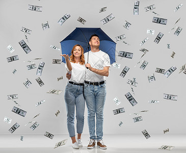 雨一直下金融,安全保护幸福的微笑夫妇穿着白色T恤,伞站金钱雨下灰色背景幸福的夫妇带着雨伞站着钱雨设计图片