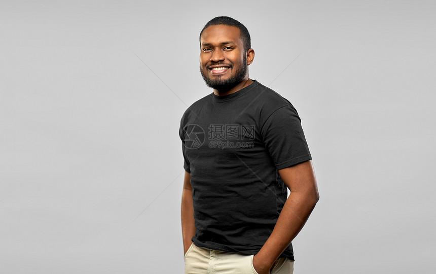 人们的快乐微笑的年轻非裔美国人,穿着灰色背景的黑色T恤微笑的非裔美国人穿黑色T恤图片