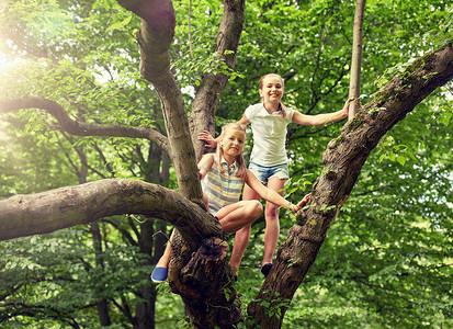 小孩上树素材友谊,童年,休闲人的两个快乐的女孩爬上树,夏天的公园玩得很开心两个快乐的女孩夏天的公园里爬上树背景