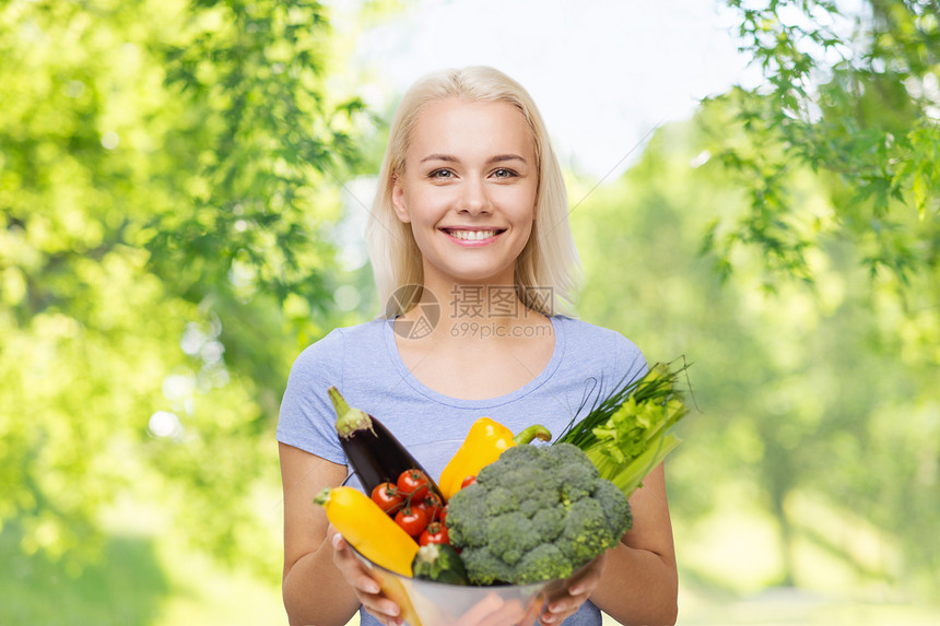 健康的饮食,食物,饮食人们的快乐的微笑年轻妇女与碗蔬菜超过绿色的自然背景带着蔬菜微笑的年轻女人图片