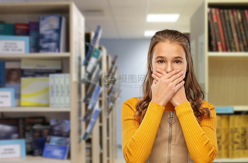 阅读,教育人的害怕十几岁的学生女孩闭口手图书馆的背景害怕学生女孩图书馆闭口图片