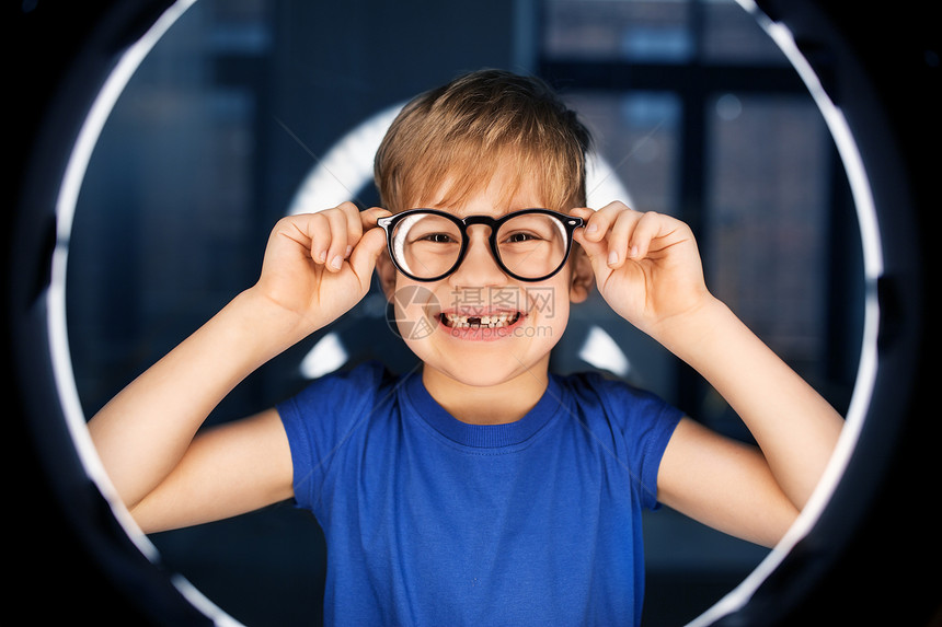 未来的技术,虚拟现实视觉快乐的微笑男孩眼镜上白色照明黑暗的房间黑暗的房间里戴眼镜的男孩图片