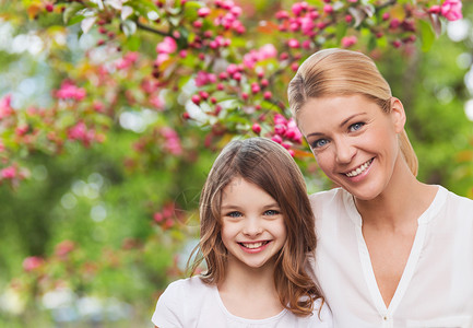 家庭,母亲人的幸福微笑的母亲女儿樱花背景快乐的母亲女儿花园里图片