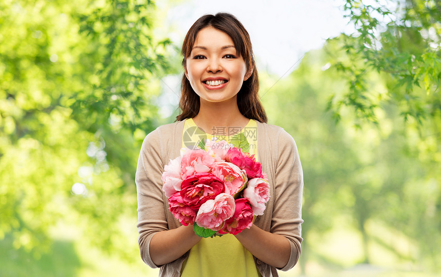 人民国际妇女日快乐的亚洲年轻妇女与束牡丹花绿色的自然背景快乐的亚洲女人带着束花图片