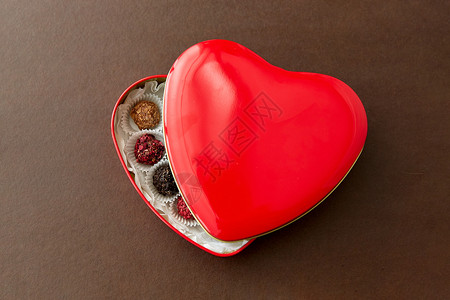 糖果,糖果食品糖果红色心形巧克力盒棕色背景红色心形巧克力盒里的糖果图片