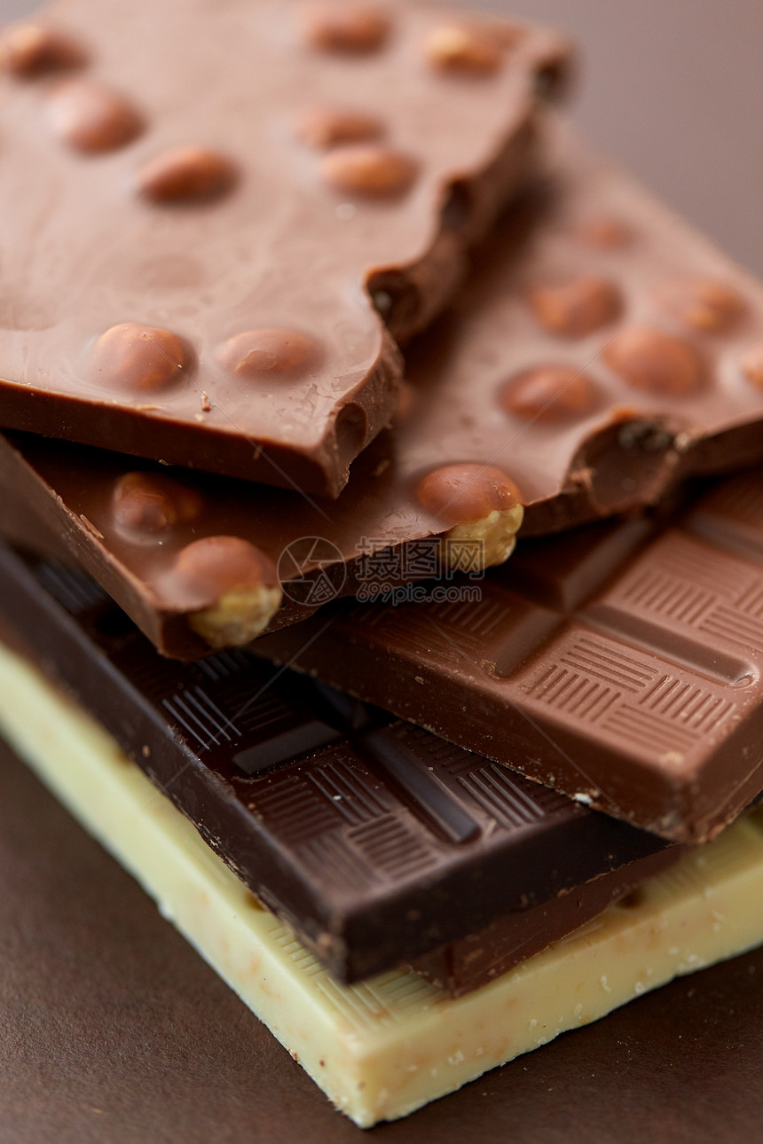 糖果,糖果食品黑,白色牛奶巧克力与坚果棕色背景同种类的巧克力棒图片