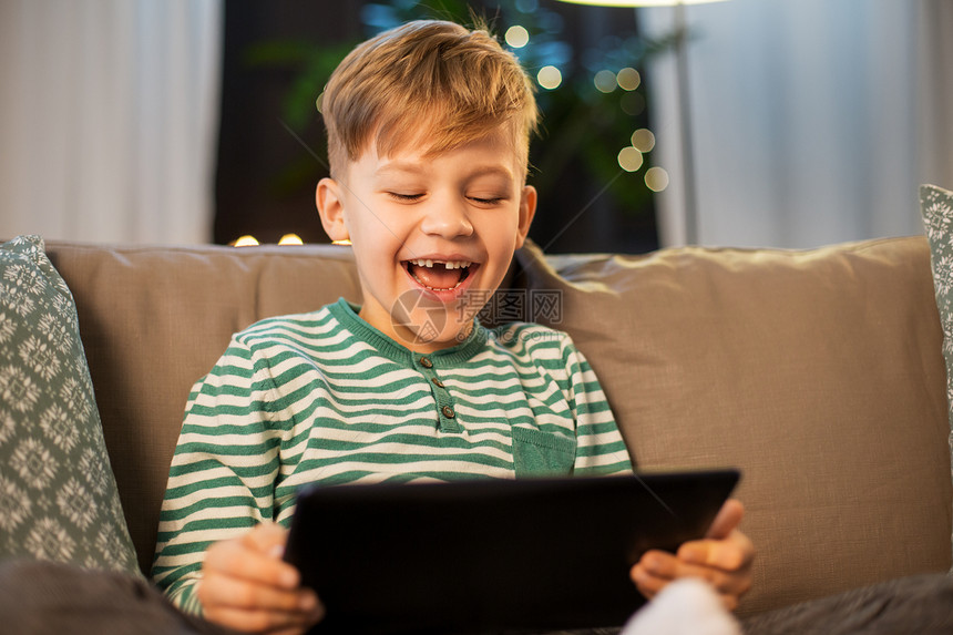 童年,技术人的快乐的微笑小男孩与平板电脑电脑家里晚上家里有平板电脑的快乐小男孩图片