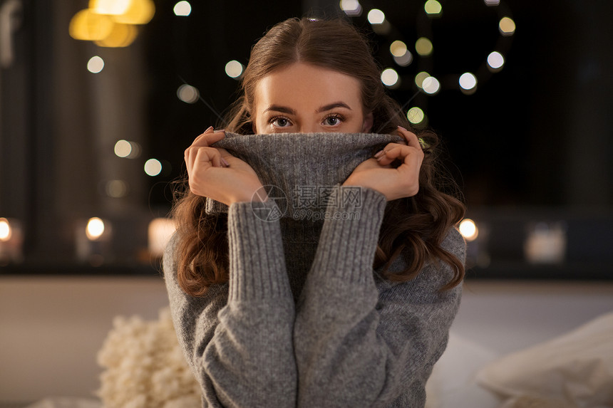 冬天,舒适人的年轻的女人穿着羊毛高领毛衣家晚上晚上穿着羊毛衫的年轻女人家图片