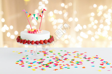 食物,甜点派生日蛋糕与糖果,花环草莓站灯光米色背景把生日蛋糕花环放看台上图片