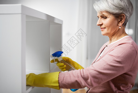 人,家务家务快乐的高级妇女清洁架与洗涤剂家里高级妇女清洁架与洗涤剂家里图片