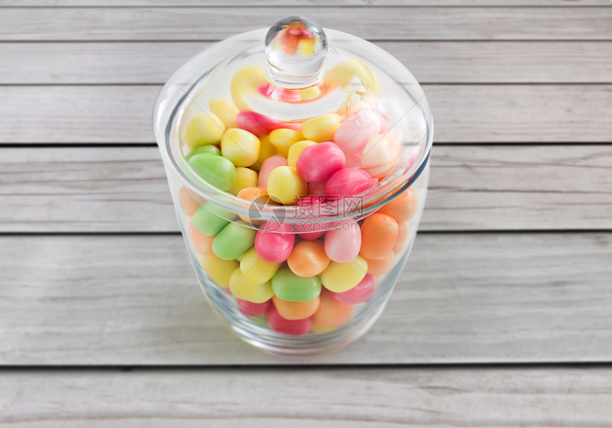 食物,糖果糖果的玻璃瓶与彩色糖果滴灰色木板背景用五颜六色的糖果滴玻璃瓶图片