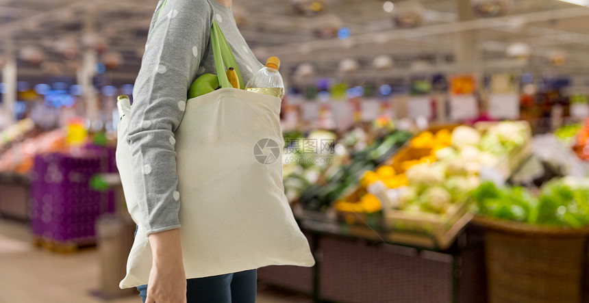 消费主义,饮食生态友好的妇女与白色可重复用的帆布袋,用于食品购物超市的背景妇女与可重复用的帆布袋食品购物图片
