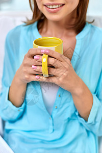人饮料休闲用杯茶或咖啡来亲近快乐的女人用杯茶或咖啡靠近快乐的女人背景图片