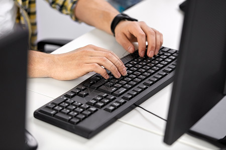 技术人的男子在电脑桌前用键盘打字图片