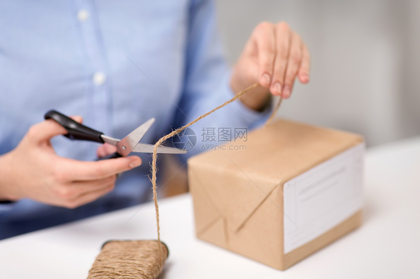 送货,邮件服务,人员装运妇女包装包裹盒剪绳剪刀邮局邮局着包裹剪绳的女人图片