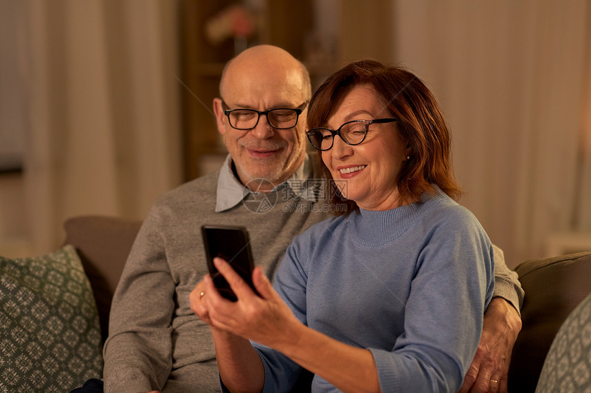 技术,老年人人的快乐的老年夫妇家里的智能手机晚上幸福的老年夫妇家里有智能手机图片