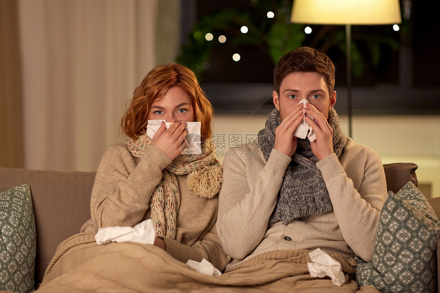 健康,流感人们的生病的年轻夫妇,家里吹鼻子生病的年轻夫妇家里用纸巾吹鼻子图片