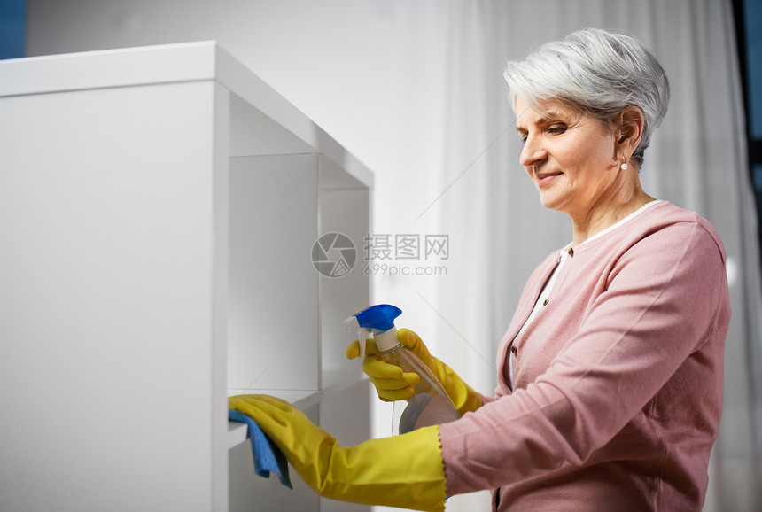 人,家务家务快乐的高级妇女清洁架与洗涤剂抹布家里高级妇女清洁架与洗涤剂家里图片