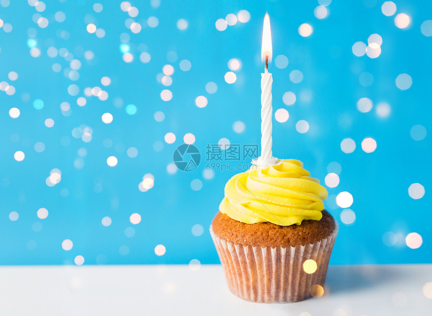 节日,庆祝,问候派生日蛋糕与黄色奶油霜个燃烧蜡烛节日灯上的蓝色背景生日蛋糕支燃烧的蜡烛图片