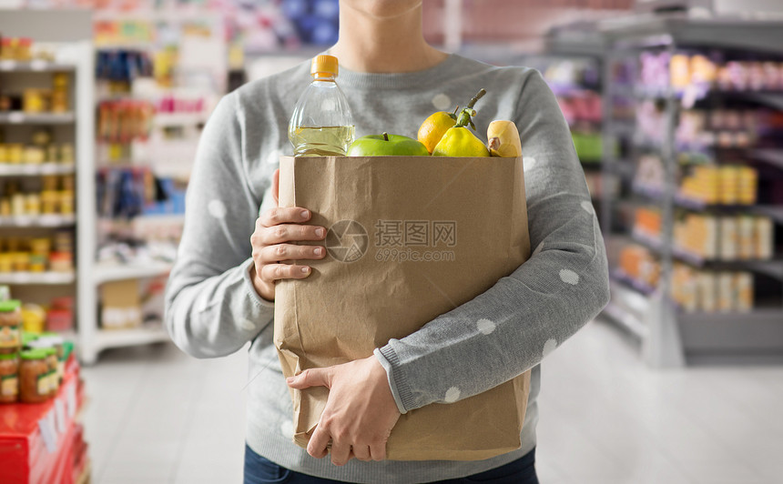 购物,健康饮食生态友好的妇女与纸袋充满食物超市的背景用装满食物的纸袋把女人关起来图片