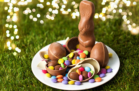 美味复活节糖果复活节,糖果糖果盘子与巧克力兔子,鸡蛋糖果滴草地上巧克力兔子,鸡蛋糖果滴盘子里背景