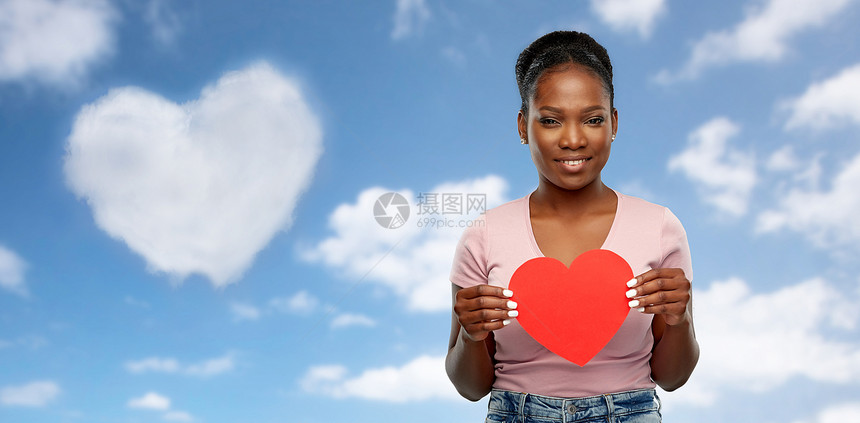 爱,情人节慈善理念快乐的非裔美国年轻妇女,红色的心灰色的背景快乐的非裔美国妇女与红色的心图片