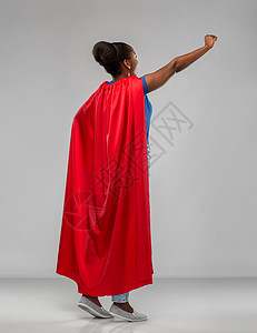 女人的力量人的快乐的非裔美国妇女红色超级英雄披风灰色背景快乐的非裔美国女人穿着红色超级英雄斗篷背景图片